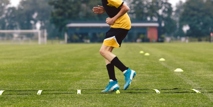 junior football club player training on soccer ladder